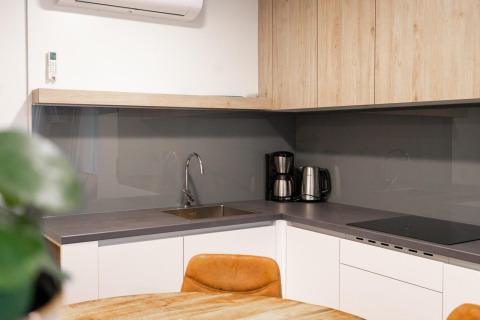 Kitchenette moderne au lodge Belsano près de Hoge Kempen en Belgique avec cafetière et armoires en bois.