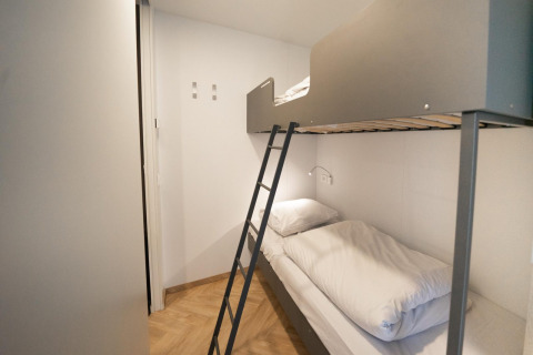 Modern bunk bed room at Belsano Lodge, Hoge Kempen, Belgium, featuring light wood flooring.