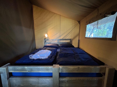 Indvendigt billede af en safari-telt soveplads med to enkeltsenge på Bergerven Lodge i Hoge Kempen, Belgien.