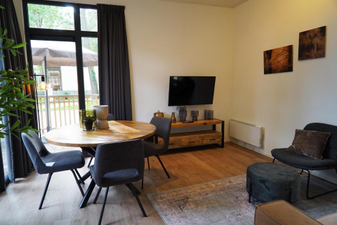 Gezellige leefruimte in Cube La Mer tiny house op Hoge Kempen, België, met eettafel en warme accenten.