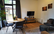 Gezellige leefruimte in Cube La Mer tiny house op Hoge Kempen, België, met eettafel en warme accenten.