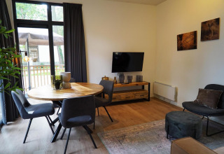 Sala moderna en la tiny house Cube La Mer en Hoge Kempen, Bélgica, con mesa de comedor y decoración acogedora.