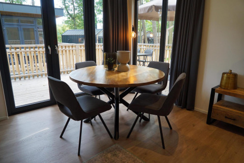 Moderne eethoek met ronde tafel en vier stoelen in het Cube La Mer tiny house in Hoge Kempen, België.