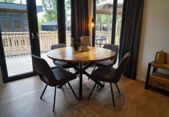 Comedor moderno con mesa redonda y cuatro sillas dentro de la tiny house Cube La Mer en Hoge Kempen, Bélgica.