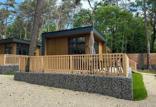 Tiny house moderna Cube La Mer con terrazza in legno immersa nella foresta di Hoge Kempen, Belgio.