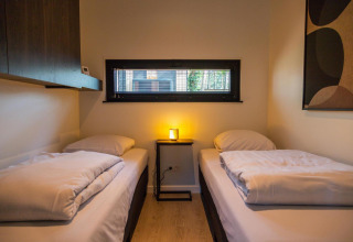 Dormitorio acogedor con dos camas individuales en Forest Cottage, Hoge Kempen, Bélgica, decoración moderna.