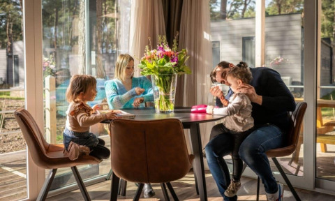 Familia compartiendo tiempo juntos en una acogedora cabaña Kempen en Hoge Kempen, Bélgica.
