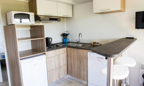 Moderne keuken in Kempen cottage, Hoge Kempen, België, met toestellen, barmeubel en barkrukken.