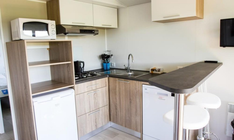 Cocina moderna en Kempen cottage, Hoge Kempen, Bélgica, con electrodomésticos, barra y taburetes.