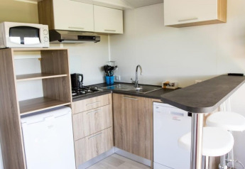 Cucina moderna al Kempen cottage di Hoge Kempen, Belgio, con elettrodomestici, bancone e sgabelli.