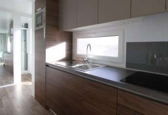 Cucina moderna in Kempen cottage a Hoge Kempen, Belgio, con armadi in legno e ampia finestra.