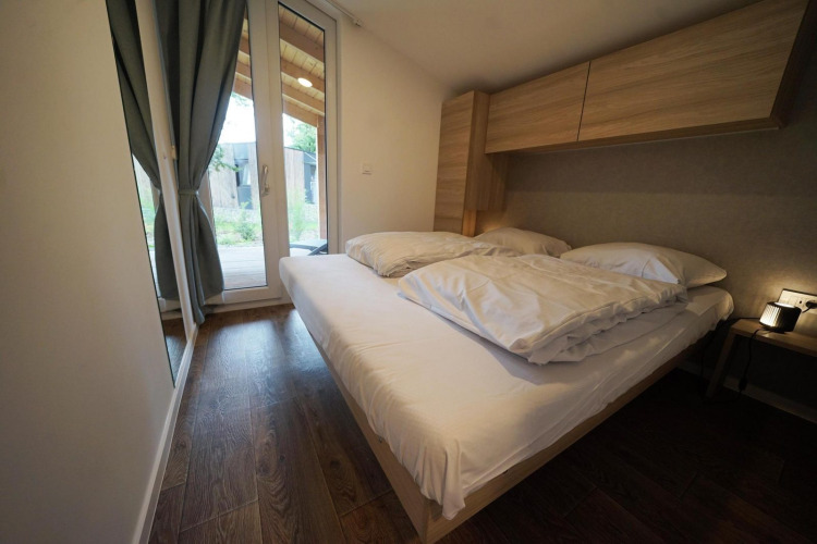 Dormitorio moderno en Panorama Cottage, Hoge Kempen, Bélgica, con cama doble y vista al jardín.