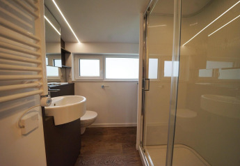Bagno moderno al Panorama Cottage, Hoge Kempen, Belgio, con doccia in vetro, lavabo e toilette.