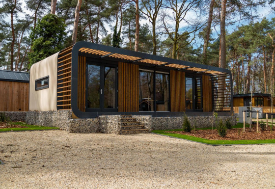 Il moderno lodge Modus Wellness a Hoge Kempen, Belgio, circondato da alberi e ambienti naturali.