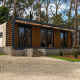 Moderne lodge ved navn Modus Wellness i Hoge Kempen, Belgien, omgivet af træer og naturelskende miljø.
