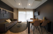 Moderne stue i Lieteberg cottage, Hoge Kempen, Belgien, med sofa, spisebord, gardiner og vægkunst.