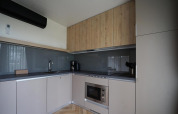Moderne køkkenfaciliteter i Lieteberg cottage i Hoge Kempen, Belgien, med træskabe og grå vægge.