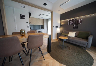 Moderne stue og spisestue i Lieteberg cottage, Hoge Kempen, Belgien, med træmøbler og kunst på væggen.