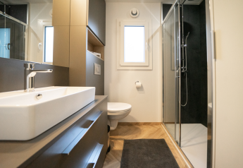 Baño moderno en la cabaña Lieteberg de Hoge Kempen, Bélgica, con ducha, inodoro y lavabo grande.