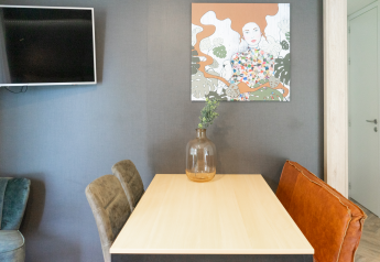 Moderne spiseplads i Lieteberg-hytten, Hoge Kempen, Belgien med kunst og dekorativ vase på bordet.
