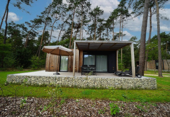 Moderne Lieteberg-hytte med terrasse og parasol i skoven, Hoge Kempen Nationalpark, Belgien.