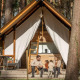 En familie sidder foran deres Papendaal lodge safaritelt i en skov, nyder naturen sammen.
