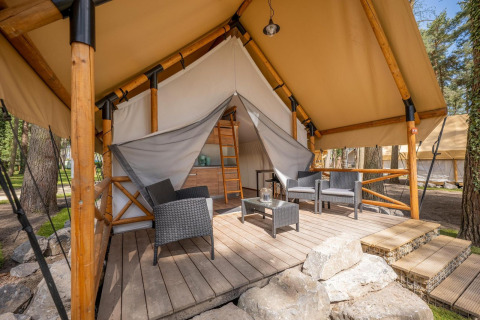 Safari-Zelt der Papendaal Lodge im Hoge Kempen, Belgien, mit Holzterrasse, Gartenmöbeln und Naturblick.
