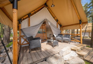 Tenda safari al Papendaal Lodge nell’Hoge Kempen, Belgio, con terrazza in legno e sedie da esterno moderne.