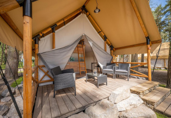 Tenda safari al Papendaal Lodge nell’Hoge Kempen, Belgio, con terrazza in legno e sedie da esterno moderne.