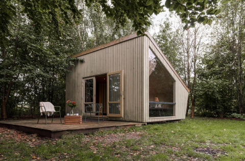 Modern tiny house with large windows in a forest, Luxe & Lazy Lodge at RØSTIG Dorst in the Netherlands.