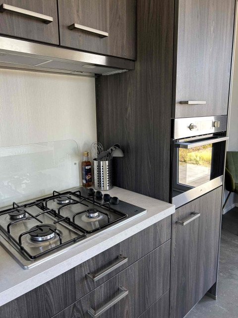 Moderne keuken bij North Sea DeLuxe lodge, Vakantiepark de Zeeuwse Parel, Nederland, met fornuis en oven.