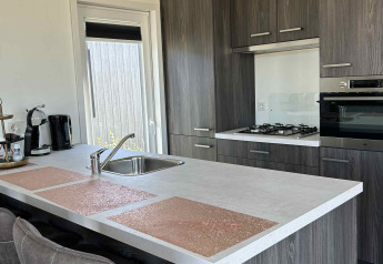 Cucina moderna nella lodge North Sea DeLuxe a Vakantiepark de Zeeuwse Parel, Paesi Bassi, con isola.