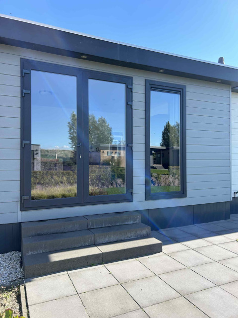 Indgang med glasdøre og trin ved North Sea DeLuxe-lodgen i Vakantiepark de Zeeuwse Parel, Holland.