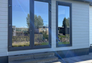 Indgang med glasdøre og trin ved North Sea DeLuxe-lodgen i Vakantiepark de Zeeuwse Parel, Holland.