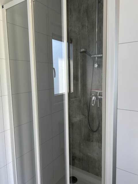 Shower cabin with glass doors and modern fixtures at North Sea DeLuxe, Vakantiepark de Zeeuwse Parel, Netherlands.