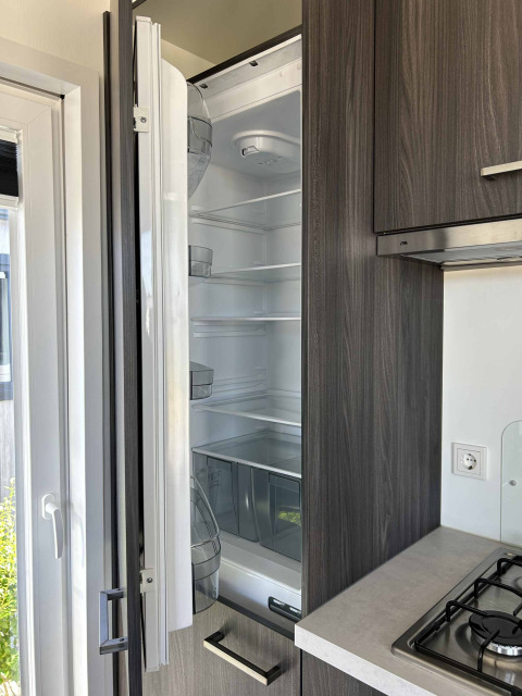 A built-in refrigerator is open in a kitchen at North Sea DeLuxe lodge at Vakantiepark de Zeeuwse Parel in the Netherlands.