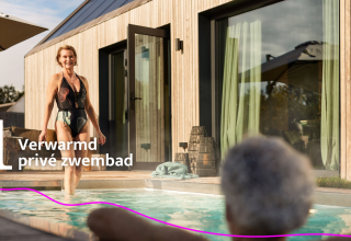 Kvinde træder ind i opvarmet privat pool ved Unbrick One lodge med sauna og pool i solskinsvejr.