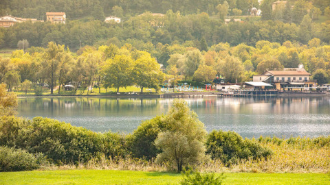 Panorama del Camping Al Lago di Lago in Veneto, Italia, con lago, alberi e edifici immersi nella natura.