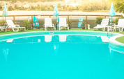 Udendørs swimmingpool med liggestole og parasoller på Camping Al Lago di Lago, Veneto, Italien.