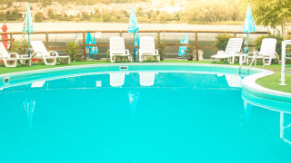 Piscina exterior con tumbonas y sombrillas en Camping Al Lago di Lago, Véneto, Italia.