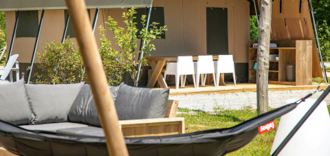 Área exterior de la tienda safari Base Lodge en Camping Al Lago di Lago, Italia, con muebles modernos.