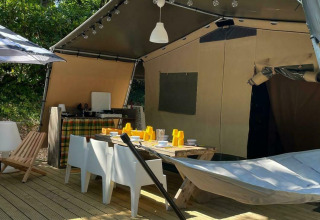 Tenda safari Base Lodge al Camping Al Lago di Lago in Italia, con terrazza, sdraio, amaca e area pranzo.