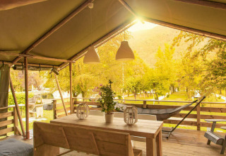 Veranda coperta in legno al Camping Al Lago di Lago, Veneto, Italia, immersa nel verde e nella natura.