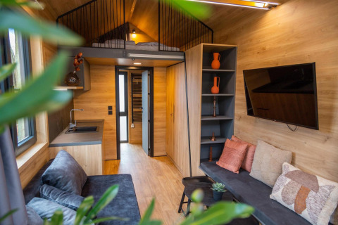 Modernes Tiny House am Hoge Kempen in Belgien mit gemütlichem Wohnbereich, Hochbett und Küche.