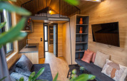 Stilfuldt interiør af Tiny House at Hoge Kempen i Belgien med moderne køkken, stue og hems.