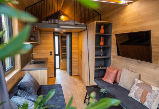 Modernes Tiny House am Hoge Kempen in Belgien mit gemütlichem Wohnbereich, Hochbett und Küche.
