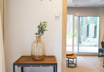 Modernes Interieur in Thor Cottage bei Hoge Kempen, Belgien, mit Glasvase auf Holztisch am Fenster.