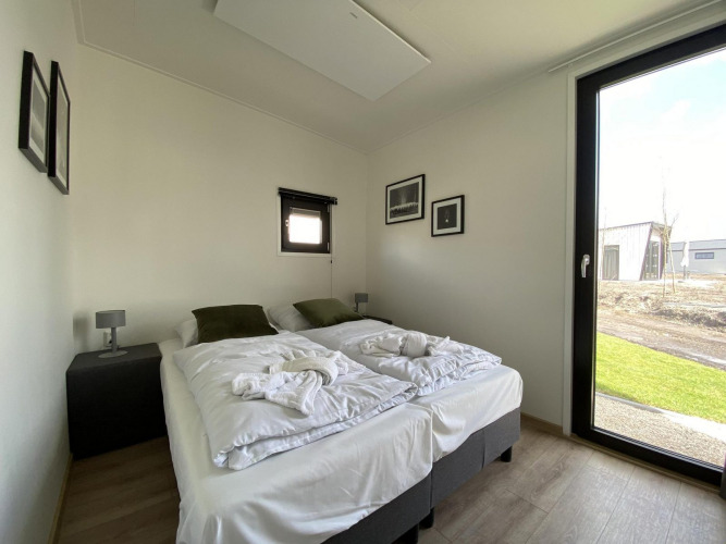 Bright modern bedroom at Just Nature Light lodge on The IJssel Islands, Netherlands, featuring double bed.