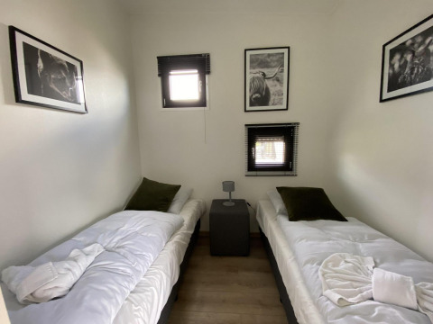 Twee eenpersoonsbedden met witte dekens in een knusse kamer, Just Nature Light, IJssel Eilanden, Nederland, met dierenkunst.