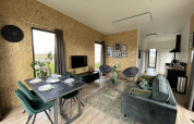 Intérieur moderne de la lodge Just Nature Light aux Îles IJssel, Pays-Bas, avec salon, salle à manger et cuisine.